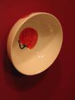 The tomato says "tawakal takfa" - He sustains us. (I.e. the tomato is being looked after and is also looking after us.)